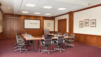 Sala de conferência com uma mesa comprida, várias cadeiras e uma tela de projetor exibindo "THE THAYER AT WRIGHT POINT".