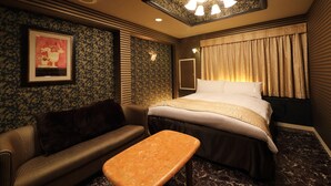 Ein Hotelzimmer mit einem Bett, einem Sofa, einem kleinen Tisch und einer Deckenleuchte.