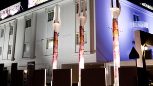 A hotel with a modern design, featuring a prominent sign and illuminated columns.