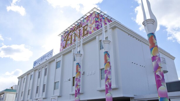 A hotel with a prominent sign reading "HOTEL FINE" and a colorful abstract design on the facade.