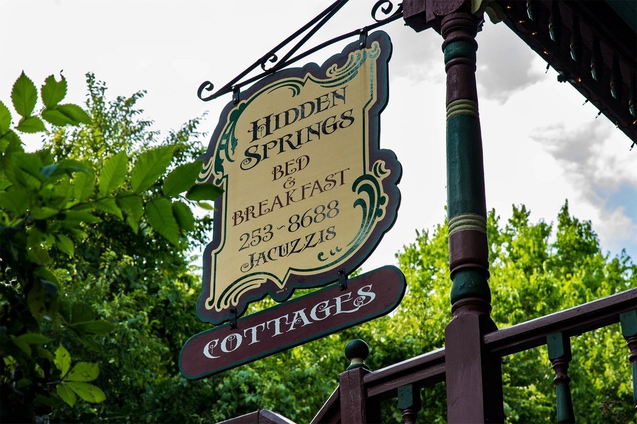 A sign for Hidden Springs Bed & Breakfast with contact number 253-8688.