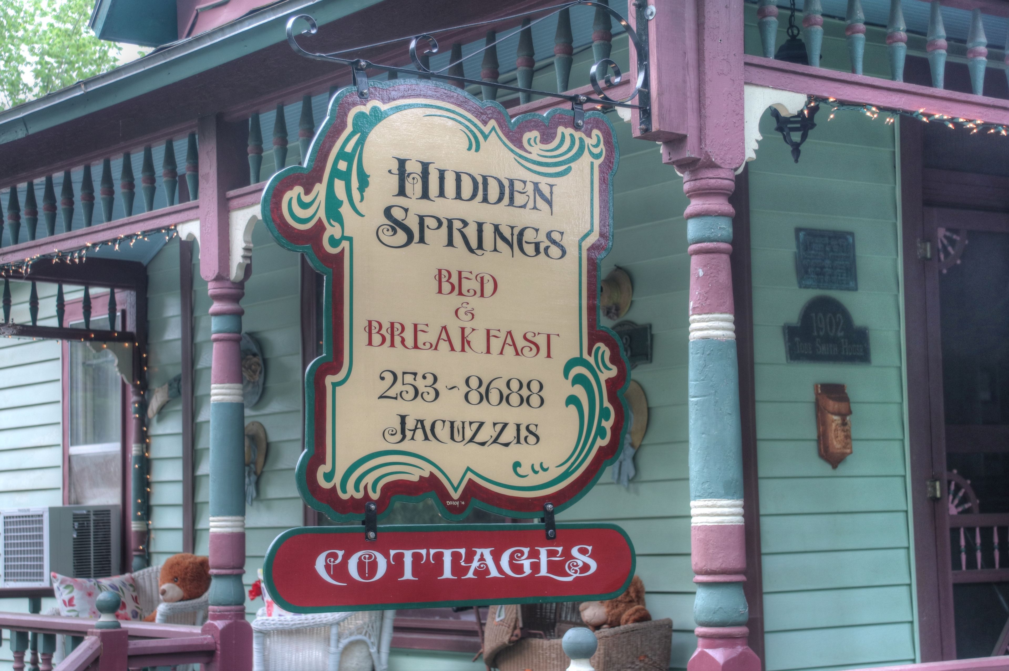A sign for Hidden Springs Bed & Breakfast with contact information and a cottage symbol.