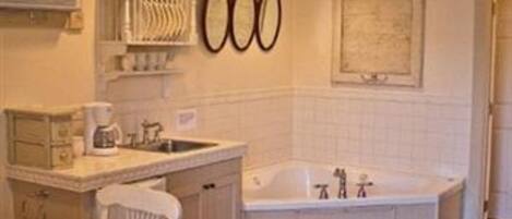 A bathroom with a sink, a mirror, a towel rack, and a bathtub.