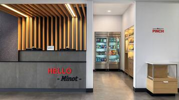 Una recepción de diseño moderno, un cartel que dice 'HELLO - Minot -' y un cartel en la pared con la palabra 'PINCH'.