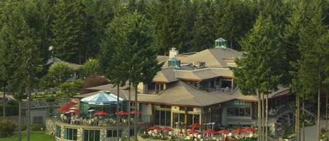 A large resort with multiple dining areas, outdoor seating, and a prominent glass conservatory.