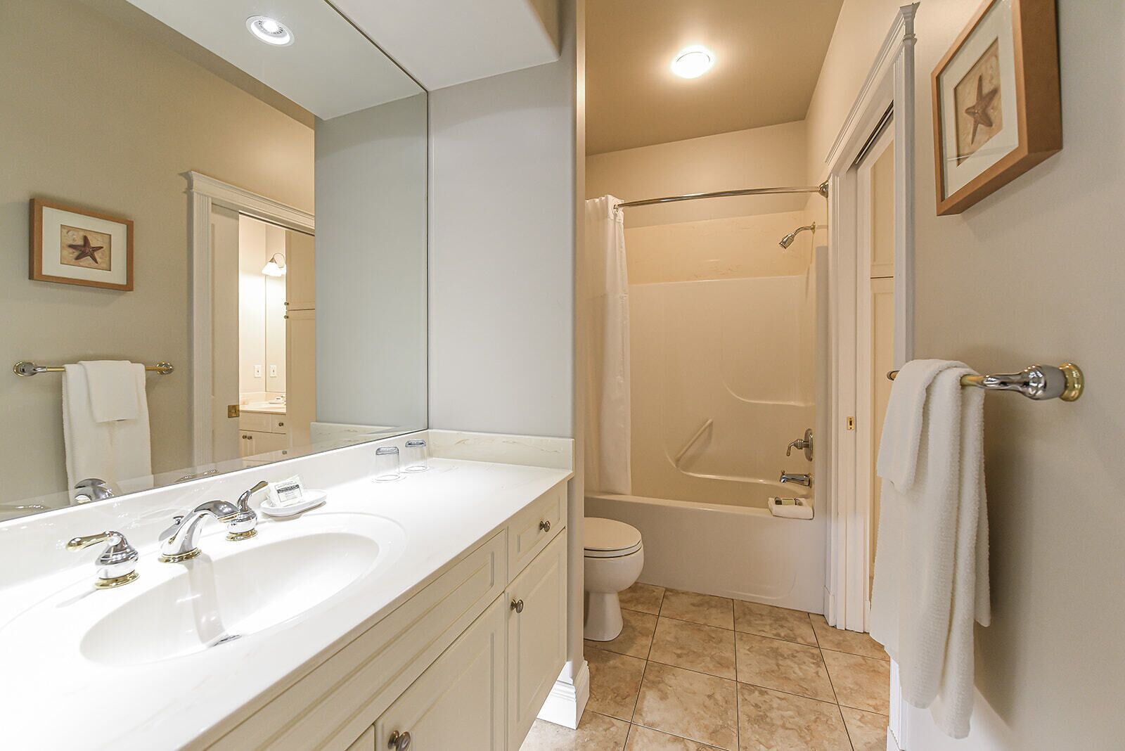 Un baño moderno con lavamanos doble, inodoro y ducha a ras de suelo.