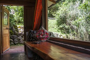 Un banco de madera con vistas a un jardín a través de una ventana.