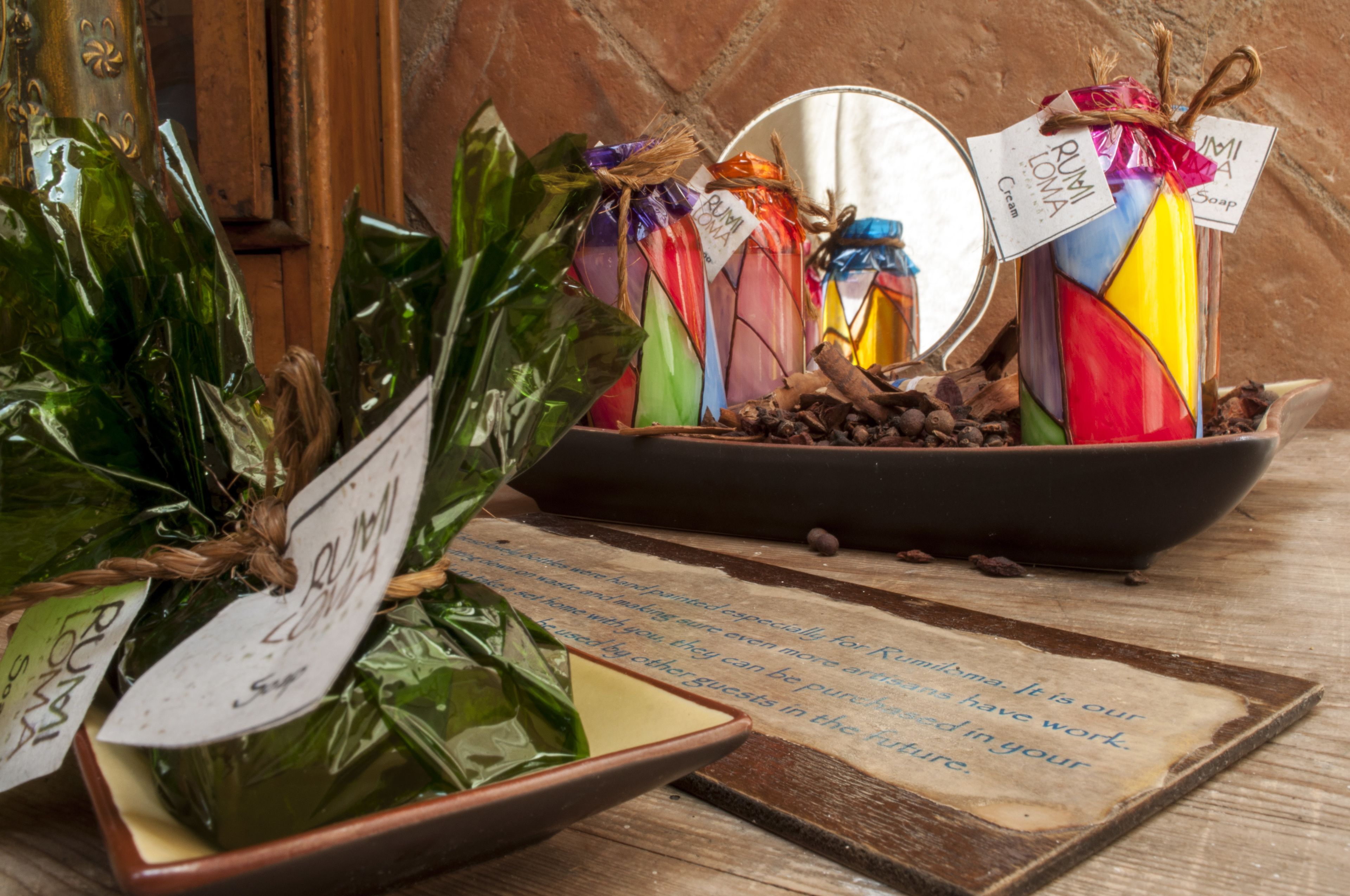 Une variété de savons aux couleurs vives et une table en bois rustique sur laquelle est posée une assiette de chocolats.