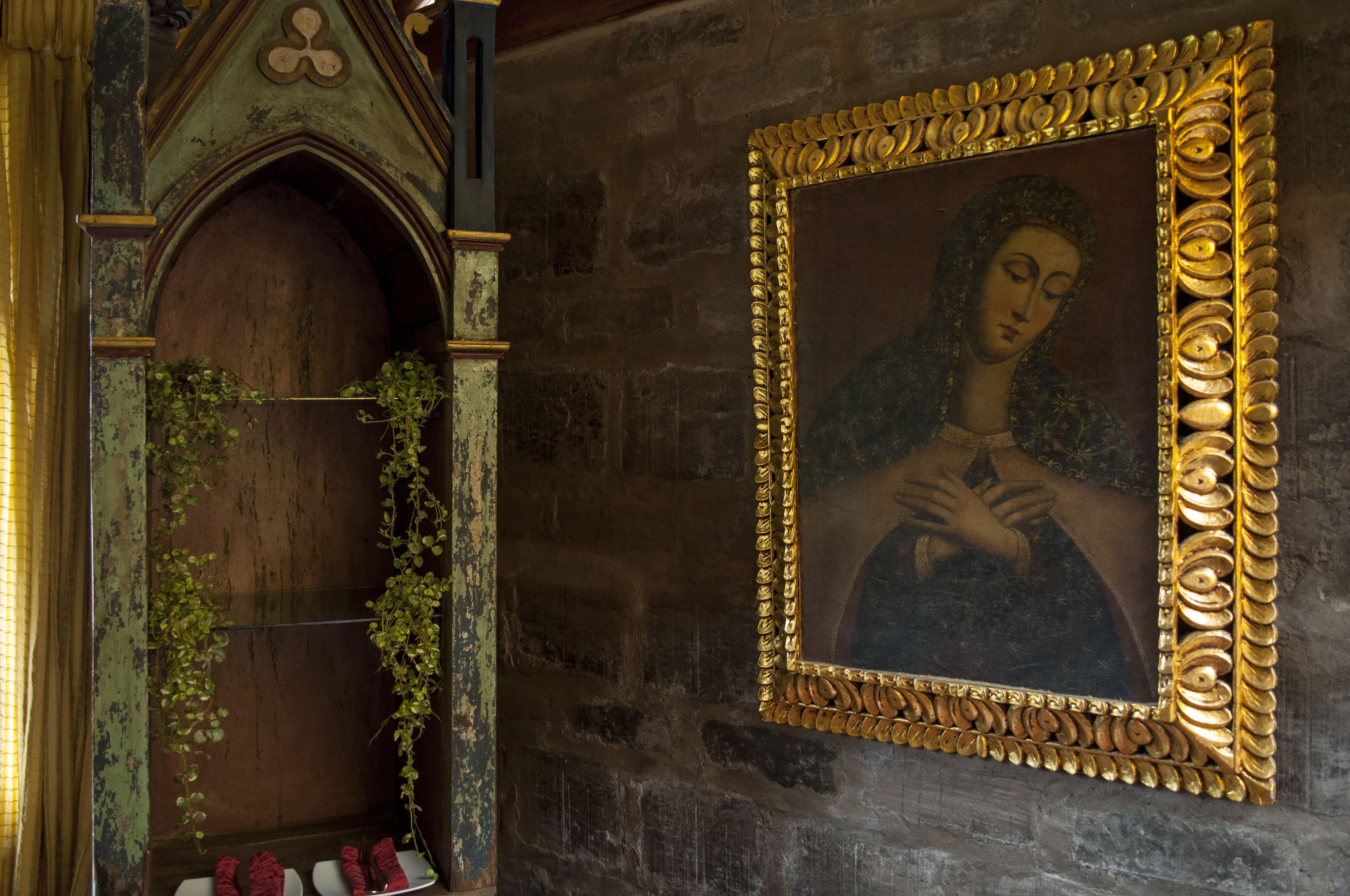 A stone wall with a framed painting and a wooden door with a green archway.