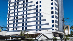 A tall, modern hotel with a distinctive checkered facade and a prominent logo on the side. - Hotel Intercity Manaus (Manaus)