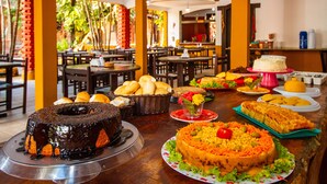 Una mesa de buffet con diversos platos, incluyendo un pastel de chocolate, una ensalada de verduras y varios tipos de pan.