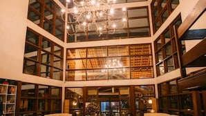 A spacious lobby with a chandelier, seating areas, and a large wooden barrel.