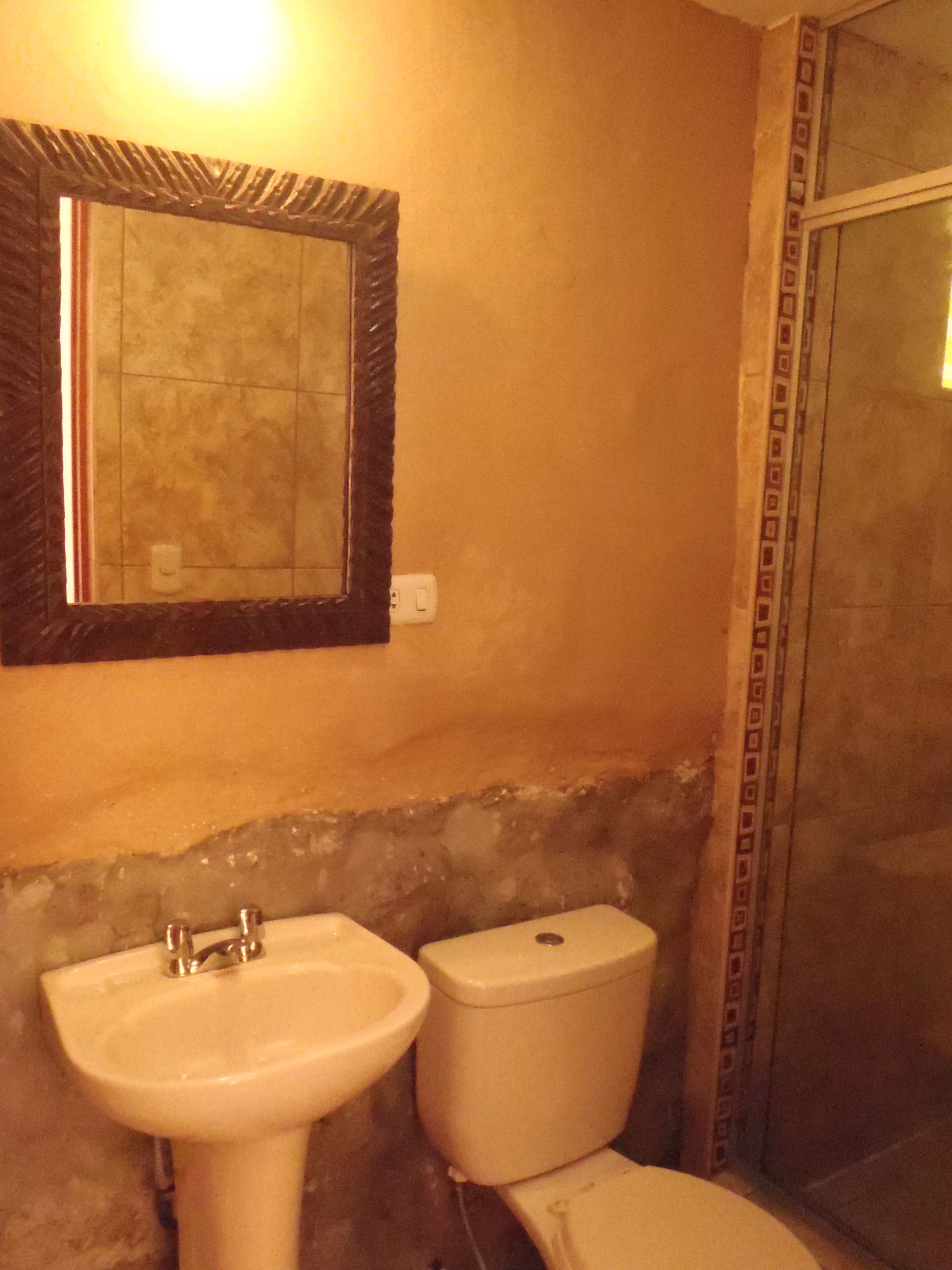 A bathroom with a sink, toilet, and a shower area.