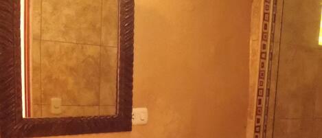 A bathroom with a sink, toilet, and a shower area.