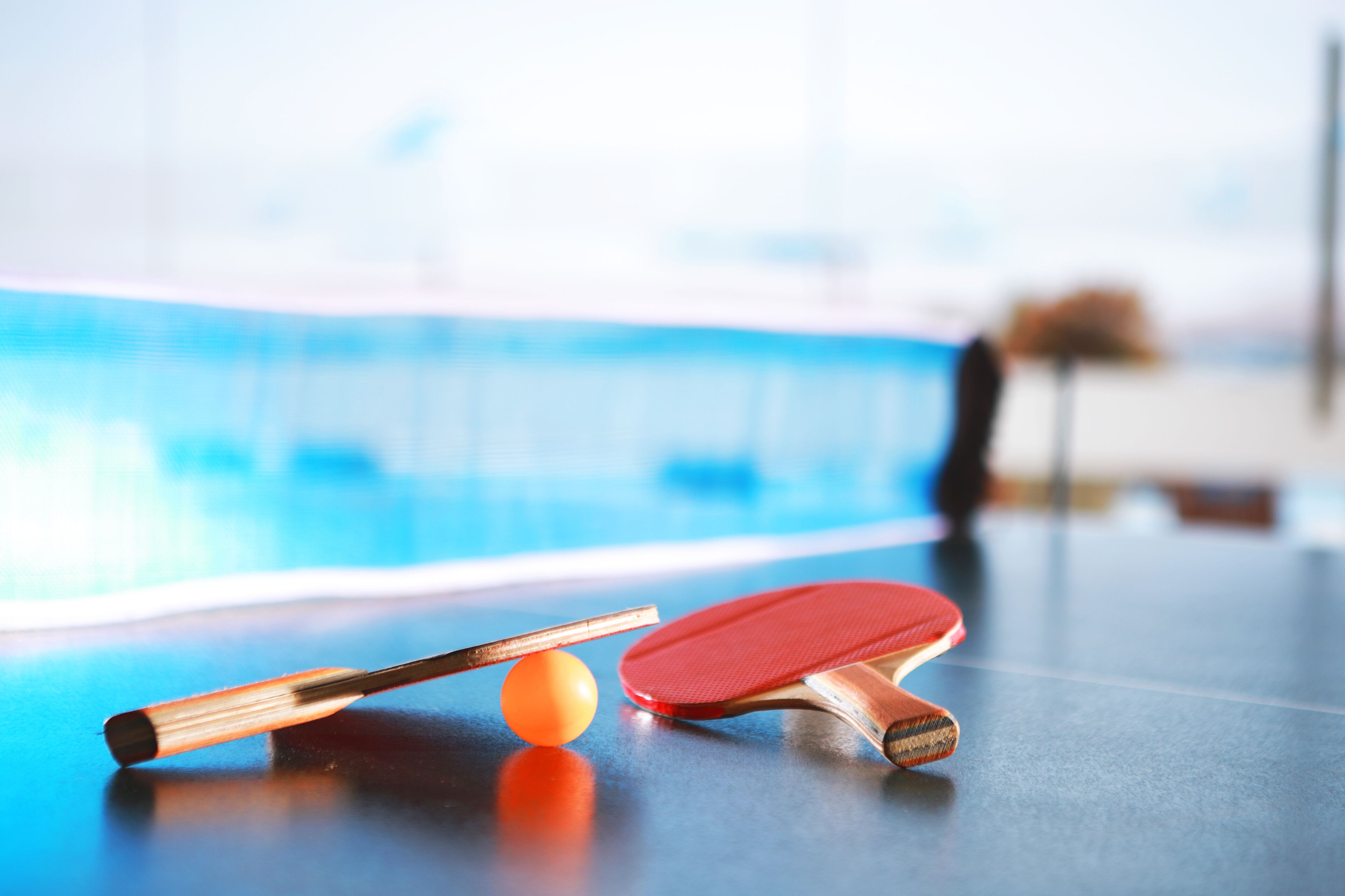 A table tennis setup with a paddle, ball, and table.