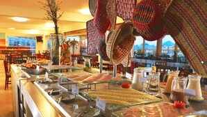 A buffet with various food items and a view of mountains in the background. - Hotel San Agustín Paracas (Paracas)