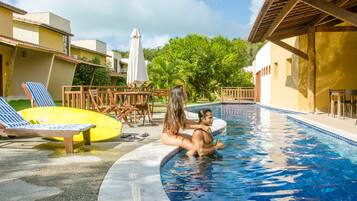 Relax by the serene pool surrounded by lounge chairs and a pergola, perfect for unwinding.