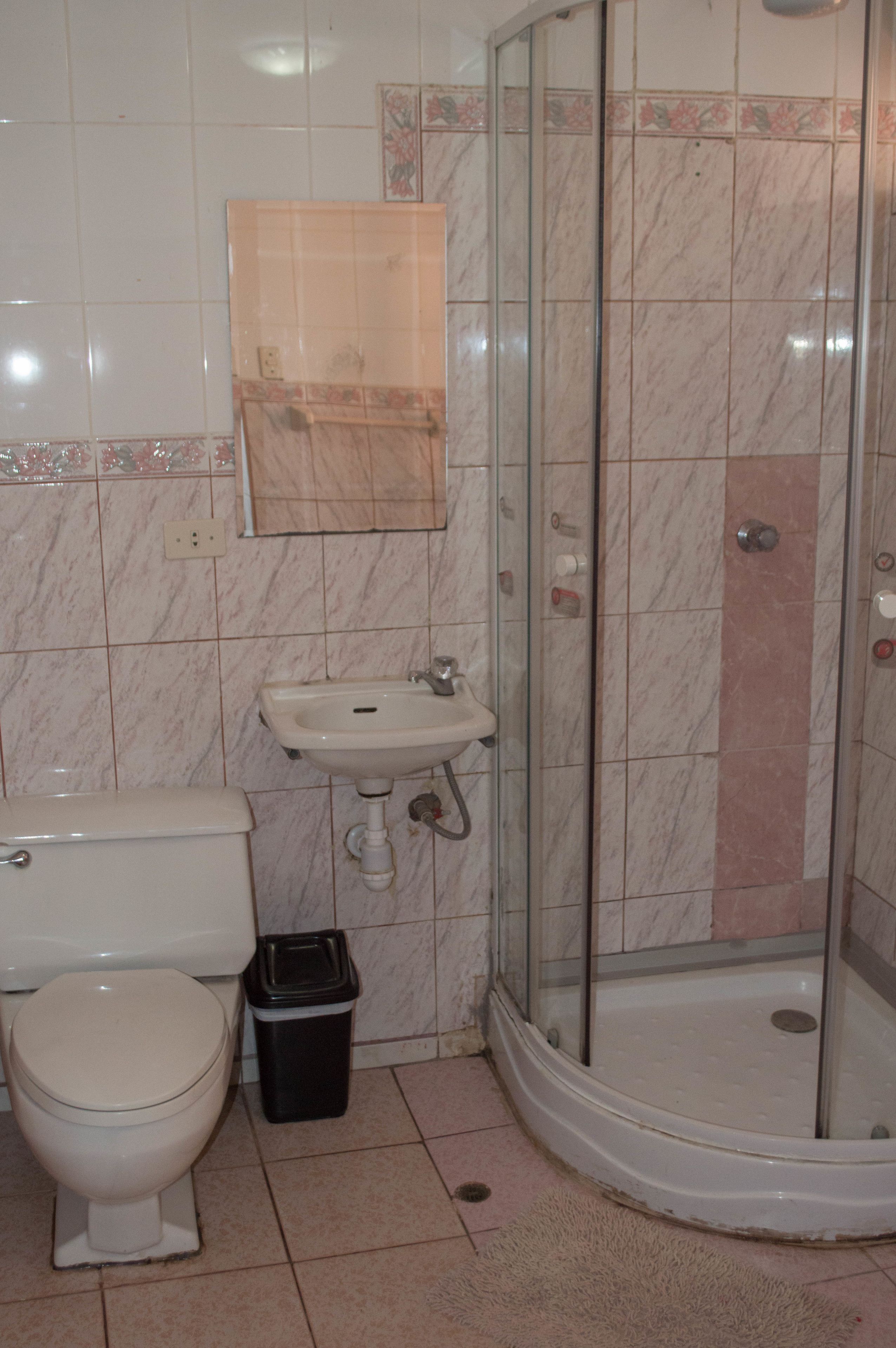 A bathroom with a toilet, sink, and glass-enclosed shower.