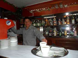 Zona de bar con una variedad de botellas de licores en estantes.