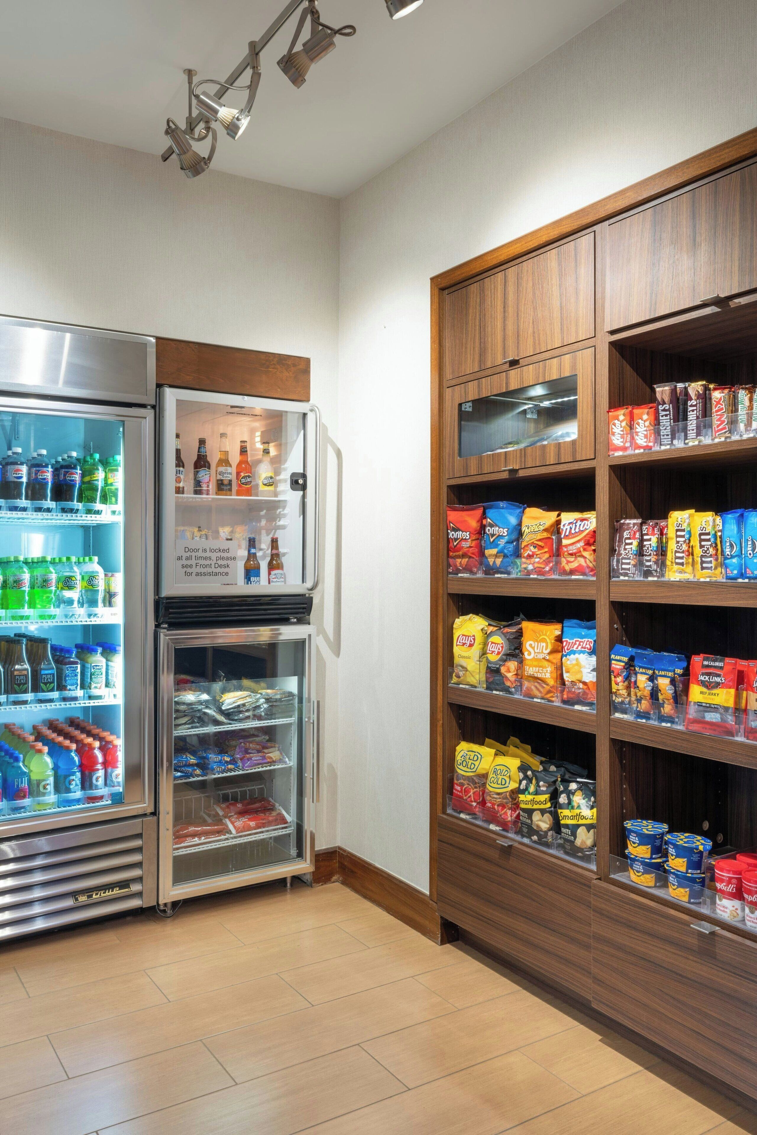 A snack bar with refrigerated drinks and a variety of snacks.