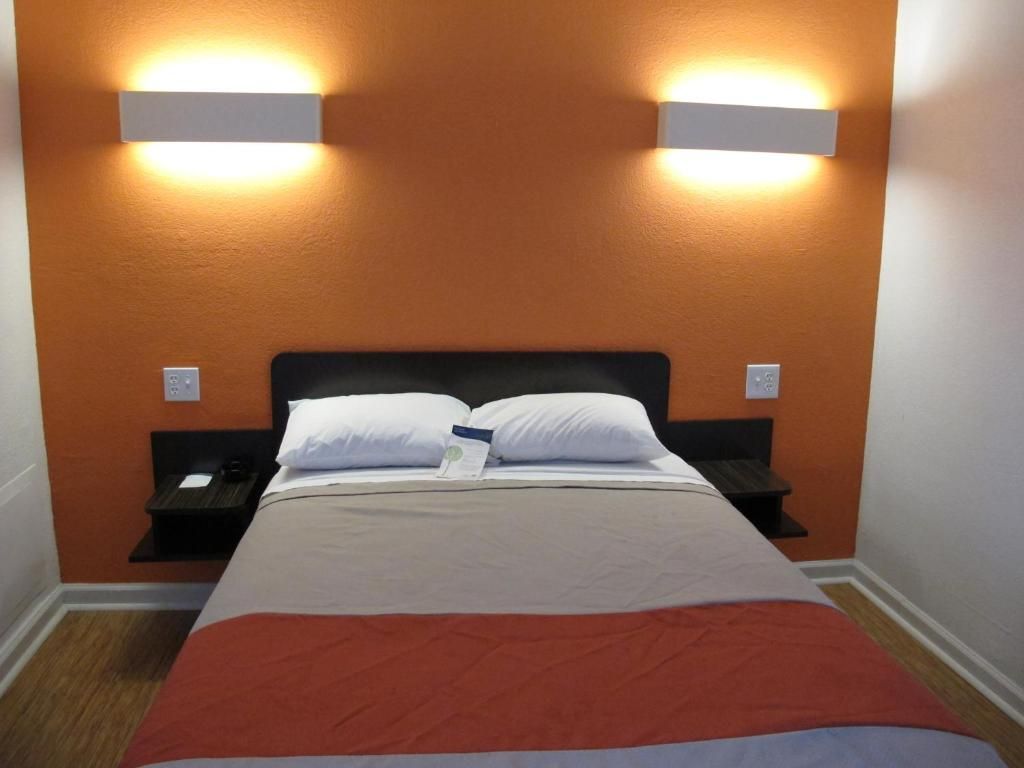 Ein Hotelzimmer mit einem Bett, zwei Nachttischen und Wandleuchten.