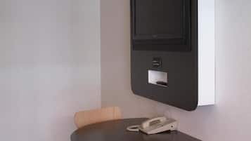 A room with a round table, a telephone, and a mounted screen.