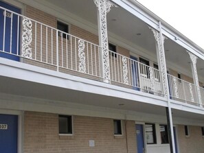 A multi-story building with a balcony featuring ornate white railings. - Motel 6 Baltimore, MD (Baltimore)