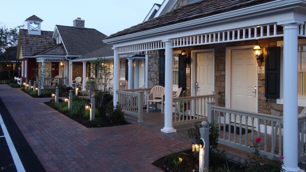 A row of houses with stone facades, white railings, and outdoor seating areas.