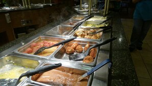 A buffet with various food items and serving utensils.