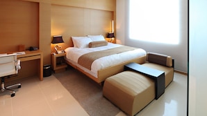 Quarto de hotel moderno com uma cama grande, abajures, uma escrivaninha e uma janela.