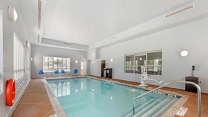 An indoor swimming pool with clear water, a lifebuoy, and a pool ladder. - Best Western Plus Miami Airport North Hotel & Suites (Miami Springs)
