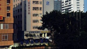 A hotel building with multiple floors, a prominent vertical sign with text, and a body of water in the foreground. - Days Hotel Dawn Fuzhou (Fuzhou)