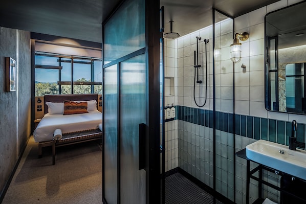 A modern hotel room with a bed, a shower, a sink, and a large window. - Ovolo Canberra, a Wyndham Hotel (Canberra)