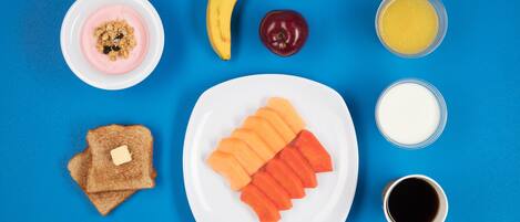 Un plato de desayuno con tostadas, plátano, manzana, jugo de naranja, leche y un tazón de yogur con granola.
