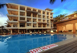 A multi-story hotel with a swimming pool, balconies, and outdoor seating areas. - Golden Tulip Goa Candolim (Candolim)