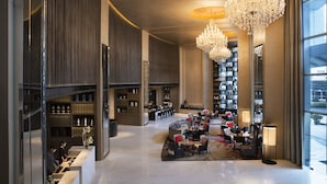 A spacious lobby with a high ceiling, large chandeliers, a central seating area, and a bookshelf filled with books. - Marriott Executive Apartments Bangkok, Sukhumvit Thonglor (Bangkok)