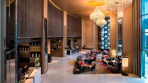 A spacious lobby with a central seating area, a bar, and a large bookshelf. - Marriott Bangkok Sukhumvit (Bangkok)