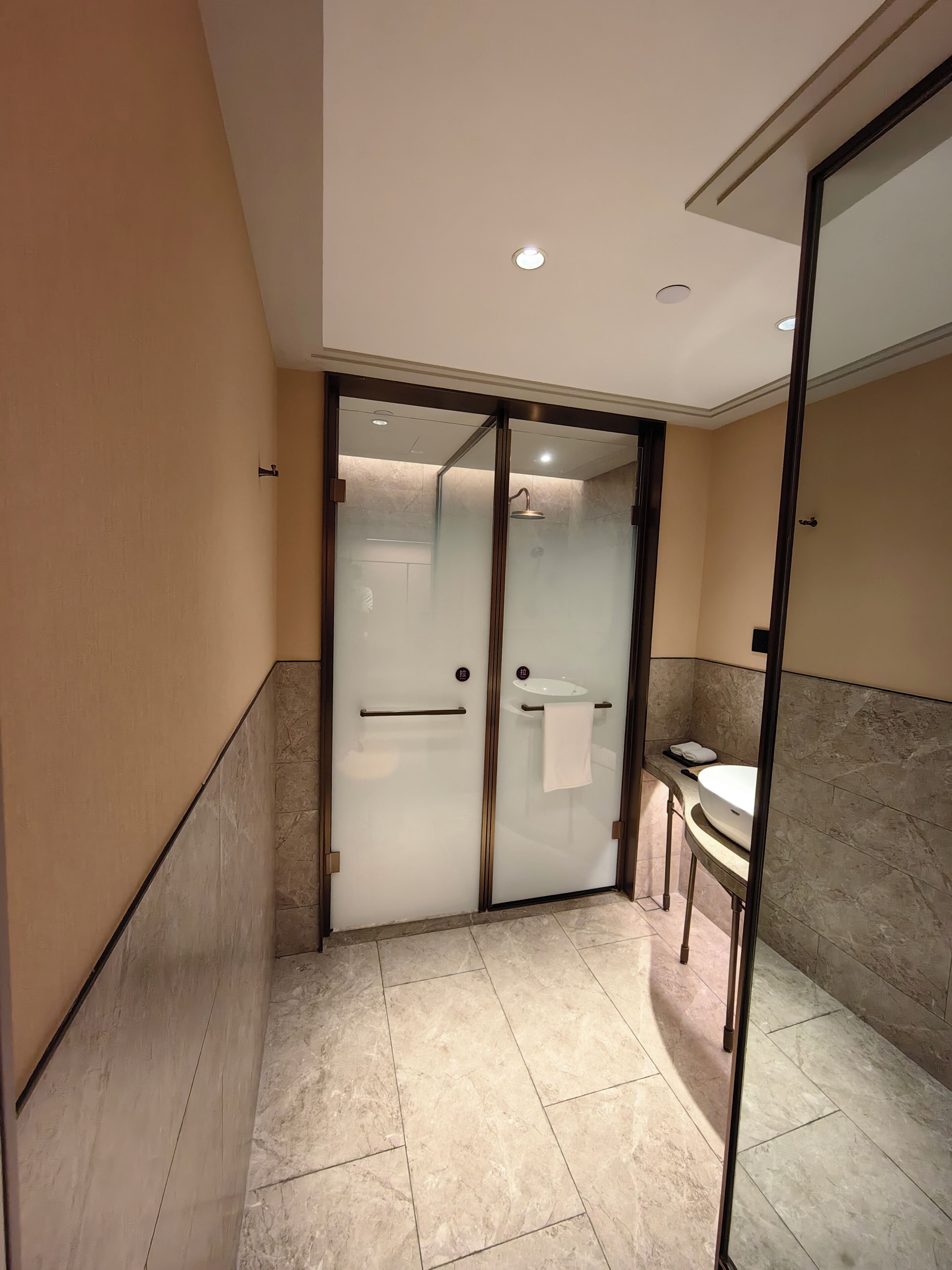 Une salle de bain moderne avec une douche à parois de verre, un meuble-lavabo et un porte-serviettes.