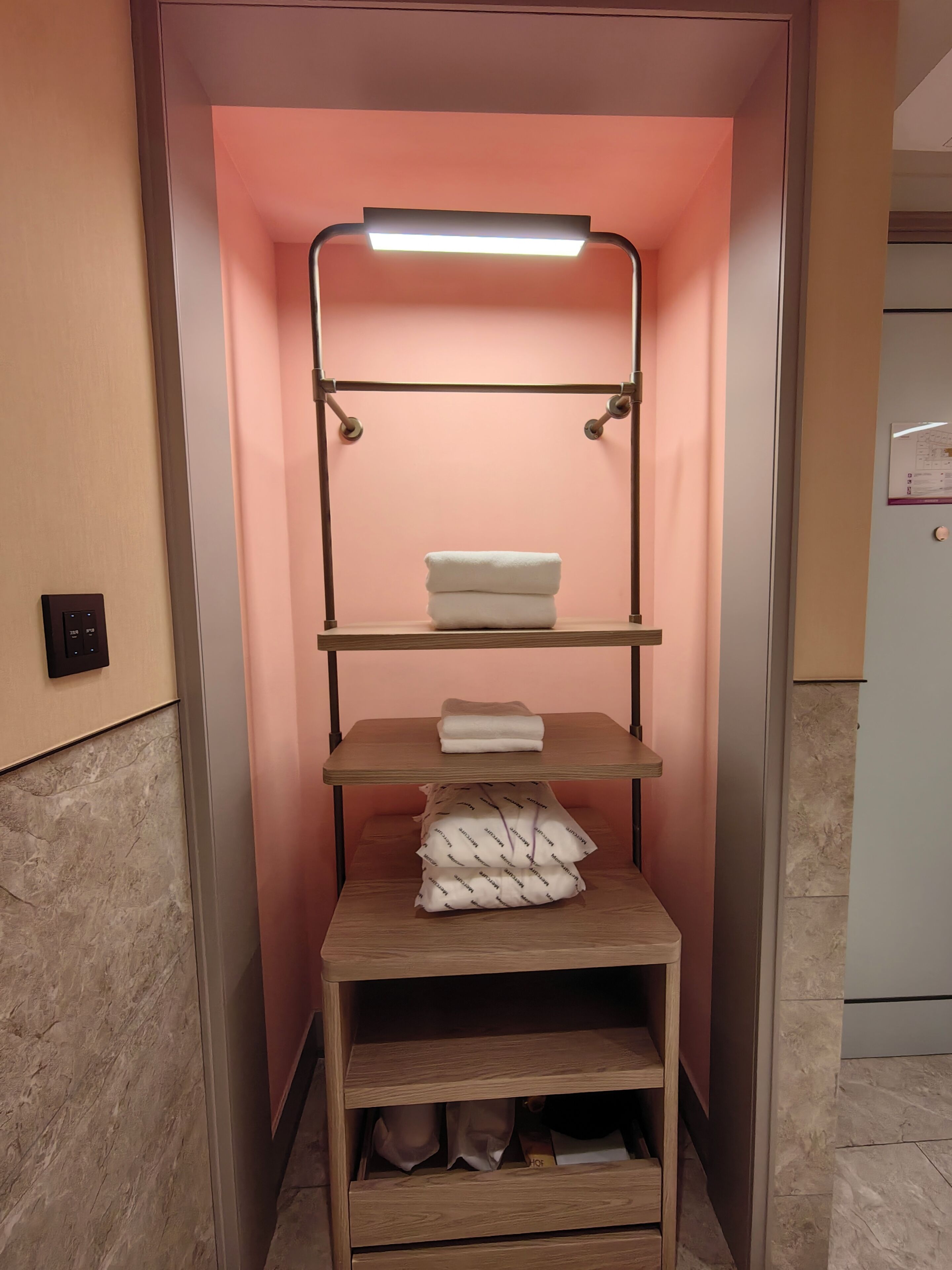 Un módulo de almacenamiento compacto con estantes, una barra para colgar y una mesa plegable.