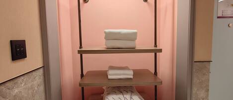 Un módulo de almacenamiento compacto con estantes, una barra para colgar y una mesa plegable.