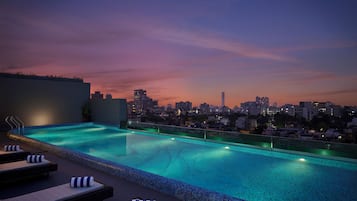 Una piscina al aire libre, sombrillas