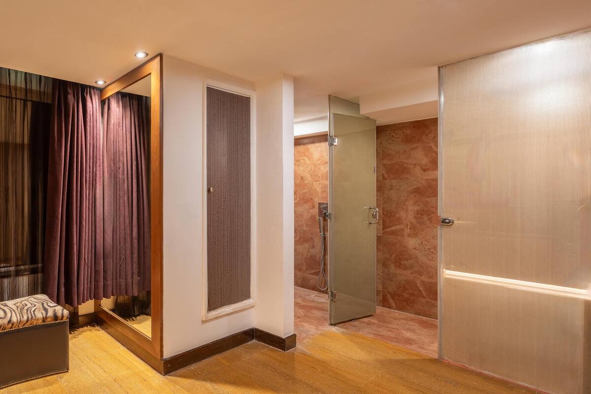 Une salle de bain moderne avec une douche en verre, un meuble-lavabo avec un miroir et un banc.
