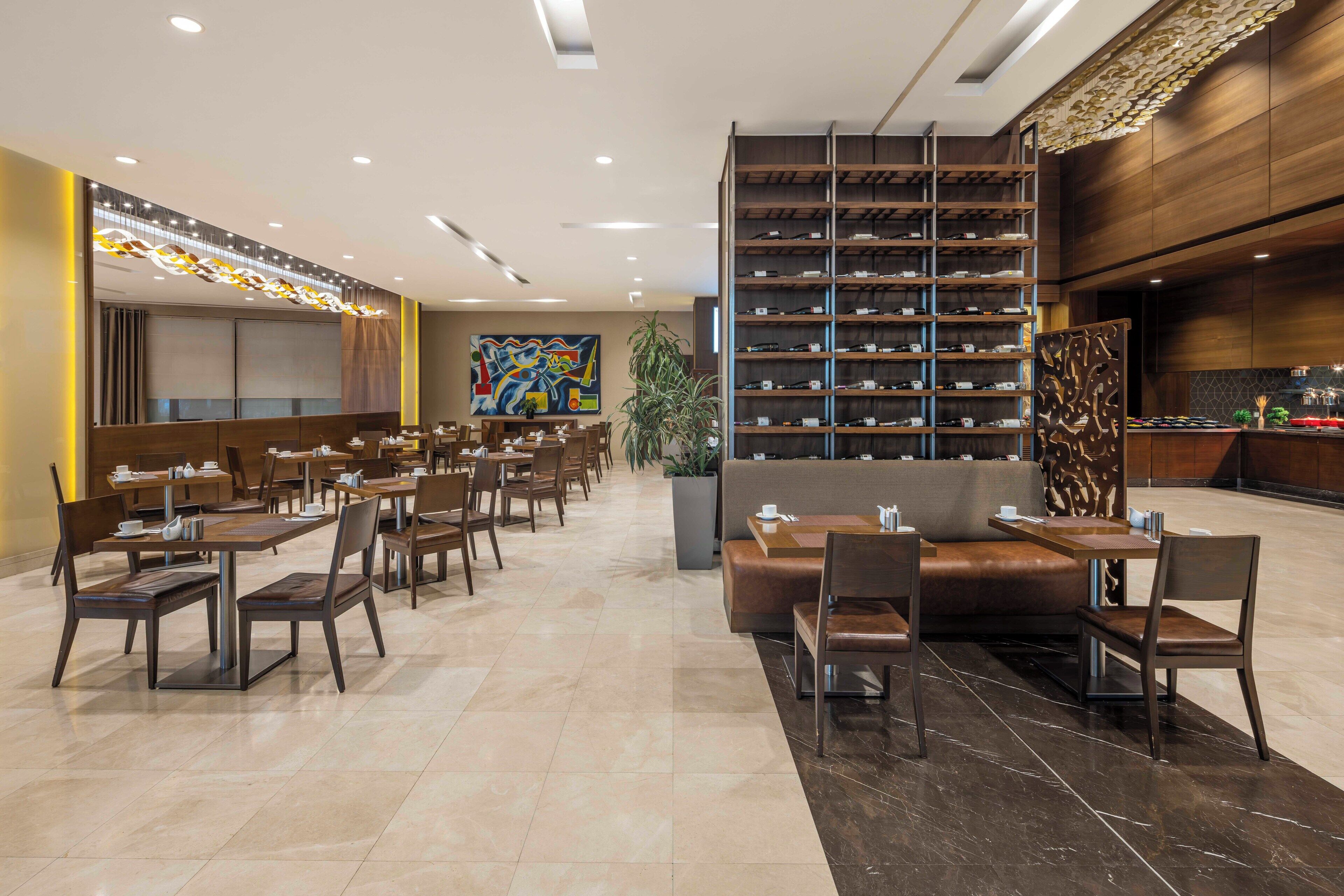 A modern hotel lobby with a seating area, a shoe display, and a large abstract painting.