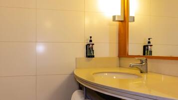 Un baño con lavabo, espejo y toallero.