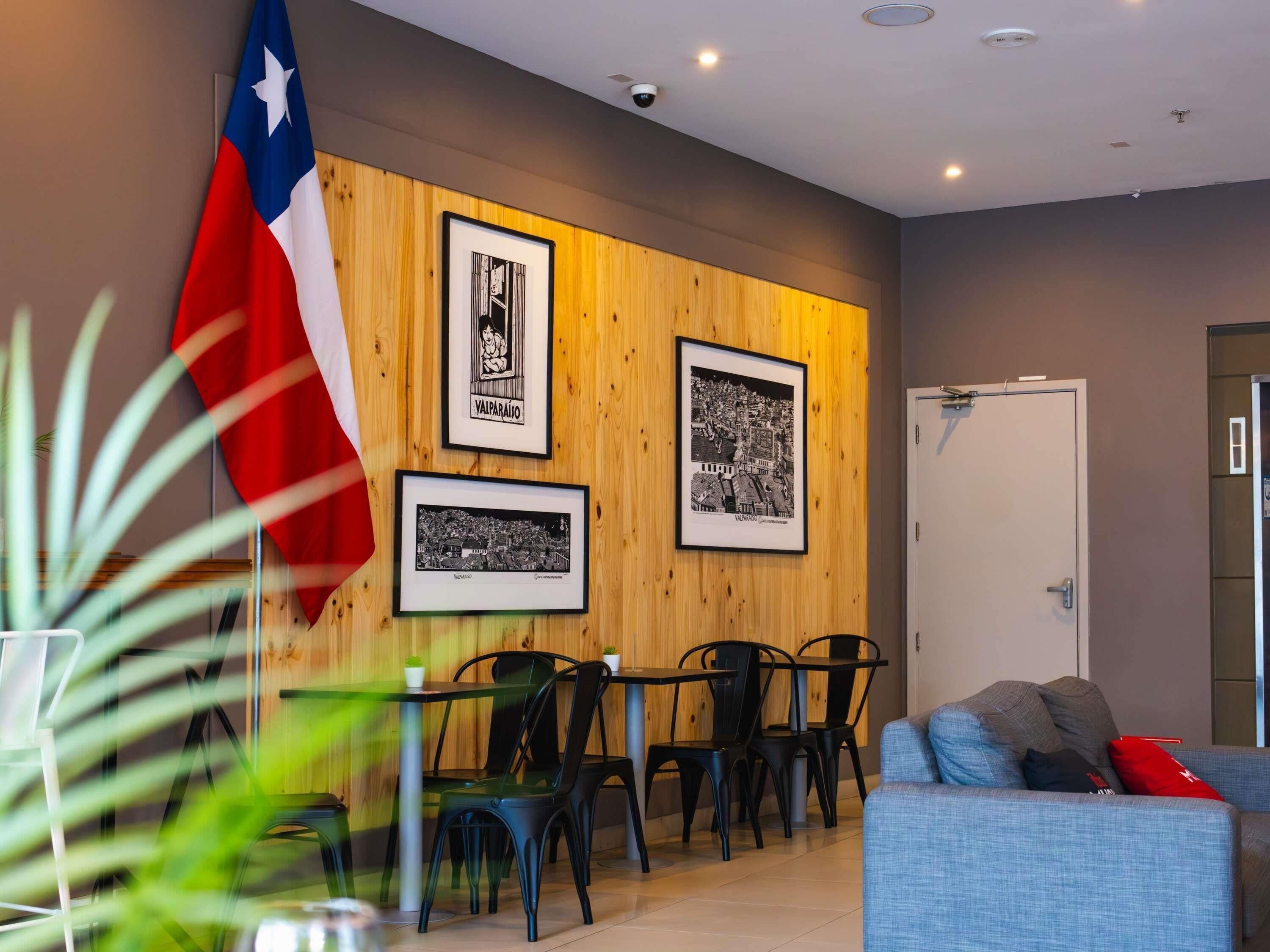 En modern inredning med en väggpanel av trä, inramade svartvita fotografier, en Texas-flagga och en sittgrupp med en soffa och stolar.