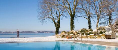 Een binnenzwembad, een buitenzwembad, parasols voor strand/zwembad
