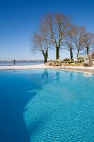 Una piscina techada, una piscina al aire libre, sombrillas