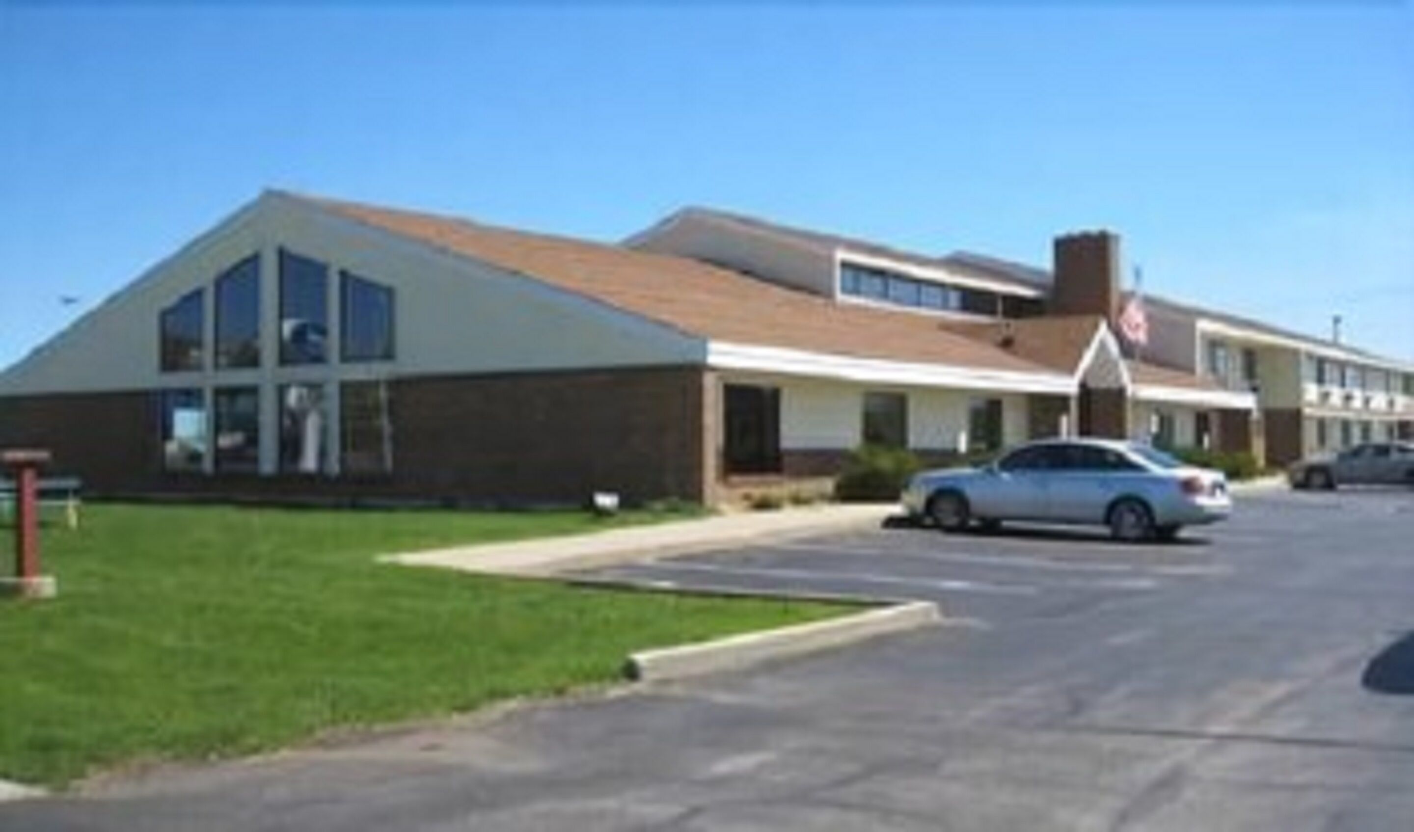 A two-story building with a flat roof and large windows.