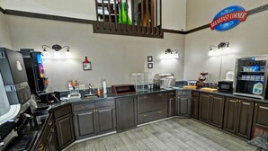 A kitchen with a coffee machine, toaster, and a refrigerator.