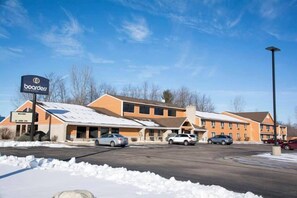 Un hôtel de ski composé de plusieurs bâtiments, doté d’un parking et où la neige recouvre le sol.